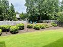 Landscaped backyard featuring a fire pit area with Adirondack chairs and a wooden fence at 4562 Brighton Ridge Dr, Apex, NC 27539
