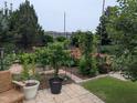 Lush backyard featuring a stone patio, potted plants, flowering plants and a variety of trees and greenery at 461 Cedar Pond Ct, Knightdale, NC 27545