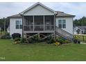Backyard featuring a screened porch, steps to the ground, colorful garden beds and a spacious grassy yard at 461 Cedar Pond Ct, Knightdale, NC 27545