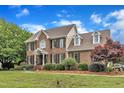 Stately brick home boasting classic architecture,dormer windows and manicured landscaping on a lush green lawn at 4620 Gomar Ln, Fuquay Varina, NC 27526