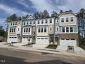 Exterior facade of new townhomes with stone accents, painted in neutral and pastel colors at 5028 Jowetts Walk Dr # 24, Cary, NC 27519