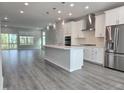 Open-concept kitchen features an island, stainless steel appliances, and hardwood floors at 5028 Jowetts Walk Dr # 24, Cary, NC 27519