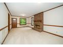 Spacious living room with a brick fireplace, large windows, and neutral carpet at 5800 Heatherbrook Cir, Raleigh, NC 27612