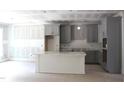 Spacious kitchen featuring grey cabinetry and center island under construction at 5900 Tranquil Cv, Youngsville, NC 27596