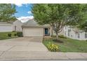 A well-maintained home featuring a blue front door, attached garage, concrete driveway and mature landscaping at 6 Newgate Ct, Durham, NC 27713