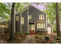 Two-story home featuring gray siding, a welcoming front entrance, and nestled in mature trees at 6035 Sentinel Dr, Raleigh, NC 27609