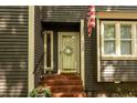 Close-up of the home's entry showing the front door, brick steps, and well-maintained landscaping at 6035 Sentinel Dr, Raleigh, NC 27609