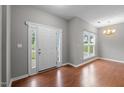 Inviting foyer featuring hardwood floors, a bright window, and a white front door at 612 Quartz Dr, Durham, NC 27703
