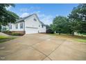 Spacious three-car garage and a long private driveway, surrounded by mature trees and landscaping at 6737 Vernie Dr, Raleigh, NC 27603