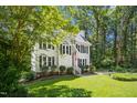 Traditional home with mature trees, attractive landscaping, neutral siding and black shutters at 6912 Baywood Dr, Raleigh, NC 27613