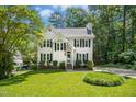 Traditional two-story home with lush lawn, mature trees, and an American flag displayed out front at 6912 Baywood Dr, Raleigh, NC 27613