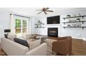 Cozy living room featuring a fireplace, ceiling fan and sliding glass doors to a patio area at 6912 Baywood Dr, Raleigh, NC 27613