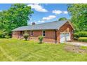 Brick home with a 2-car garage and a well-maintained green lawn at 750 Greenleaf Rd, Angier, NC 27501