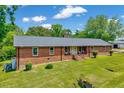 Brick home with a well-manicured lawn and inviting front porch, with an exterior utility unit at 750 Greenleaf Rd, Angier, NC 27501