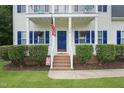 Inviting front entrance with American flag, hanging flower baskets, and manicured shrubbery at 750 Raymond Dr, Clayton, NC 27527
