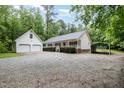 Charming home featuring a large front yard, a detached two-car garage, and an attached carport at 7603 Nichols Dr, Rougemont, NC 27572
