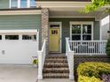 Welcoming front entrance with a charming yellow door, brick steps, and a cozy porch at 78 Salt Cedar Ln, Chapel Hill, NC 27516