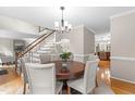 Elegant dining room featuring a round table with seating for six and a staircase with white railing at 106 Ridgepath Way, Cary, NC 27511