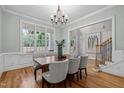 Bright dining room featuring hardwood floors, wainscoting, stylish chandelier, and natural light at 109 Henrys Ridge Rd, Pittsboro, NC 27312