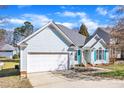 One-story home with blue siding, blue shutters, an attached garage, and a well-maintained lawn at 11113 N Radner Way, Raleigh, NC 27613