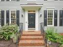 Close-up of the home's front door, featuring brick steps and attractive landscaping at 113 Bergeron Way, Cary, NC 27519