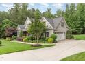 Well-maintained home featuring a side-entry garage, manicured lawn, and beautiful landscaping at 114 Margaret Mann Way, Pittsboro, NC 27312