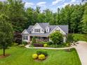 Beautiful home with lush landscaping, mature trees, and a well-manicured lawn creating an inviting curb appeal at 114 Margaret Mann Way, Pittsboro, NC 27312