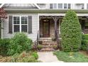 Charming front porch with stone steps, elegant door, and manicured greenery creating an inviting entry at 114 Margaret Mann Way, Pittsboro, NC 27312