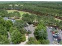 An aerial view of the home surrounded by lush trees, next to a golf course and a parking lot at 1300 Heritage Club Ave, Wake Forest, NC 27587