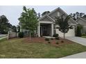 Attractive home showcasing manicured landscaping, stone accents, and a cozy front porch with rocking chairs at 1357 Prevenient Dr, Wake Forest, NC 27587