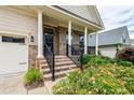 Inviting front porch with brick columns, black railings, and blooming flowers at 1577 Tice Hurst Ln, Apex, NC 27502
