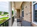 Cozy front porch featuring brick columns, black railings, and comfortable seating at 1577 Tice Hurst Ln, Apex, NC 27502
