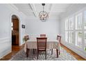 Elegant dining room with coffered ceiling, chandelier, hardwood floors, and natural light at 1633 Lakestone Village Ln, Fuquay Varina, NC 27526