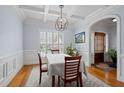 Elegant dining room featuring wainscoting, hardwood floors, and a view of the front entryway at 1633 Lakestone Village Ln, Fuquay Varina, NC 27526