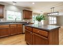 Well-designed kitchen island with stainless steel appliances, countertops, wood cabinets, and a window view at 1833 Creek Oak Circle Cir, Fuquay Varina, NC 27526