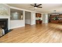 Open concept living room featuring hardwood floors, a fireplace, a ceiling fan, and neutral paint colors at 1833 Creek Oak Circle Cir, Fuquay Varina, NC 27526