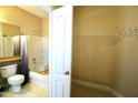Bathroom featuring a bathtub with shower, a toilet, and an open door to a walk-in closet at 1912 Parkside Village Dr, Clayton, NC 27520