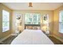 Well-lit bedroom features neutral decor, a comfortable bed, and serene window views at 1912 Parkside Village Dr, Clayton, NC 27520