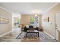 Cozy living room with neutral decor, wood-look floors, and a comfortable sofa at 1912 Parkside Village Dr, Clayton, NC 27520