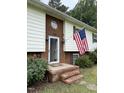Close up on the charming front entrance, showcasing brickwork and an American flag display at 210 Crest Rd, Henderson, NC 27536