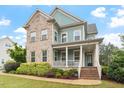 Attractive two-story home with brick accents, a welcoming front porch, and well-maintained green lawn at 212 Preatonwood Dr, Apex, NC 27539