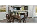 Eat-in kitchen featuring dark cabinetry, stainless appliances, and a dining table for four at 220 Gianna Dr, Lillington, NC 27546