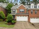 Charming two-story brick townhome with a spacious two-car garage and well-maintained landscaping at 238 Langford Valley Way, Cary, NC 27513