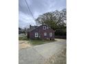 Rear view of a two-story home with a concrete driveway and mature trees at 2507 Chapel Hill Rd, Durham, NC 27707