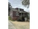Back of home with porch, staircase, ground level garage and mature landscaping at 2507 Chapel Hill Rd, Durham, NC 27707