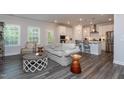 Open-concept living room with modern finishes, hardwood floors, and a kitchen view at 2521 Heathland Farm Dr, Fuquay Varina, NC 27526