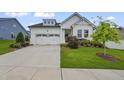 Charming white home with a two-car garage, manicured lawn, and inviting curb appeal on a sunny day at 2537 Cedar Hedge Ct, Apex, NC 27523