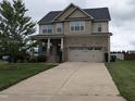 Charming two-story home with a wide driveway and attached two-car garage, complemented by a lush green lawn at 319 Brinkley Cir, Mebane, NC 27302
