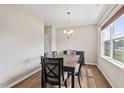 Well-lit dining area featuring a modern chandelier, hardwood floors, and a large window at 328 Avery Meadows Dr, Smithfield, NC 27577