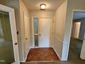 Entryway featuring a white door with glass, wood look flooring, and adjacent rooms at 3559 Mill Run, Raleigh, NC 27612